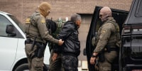 Immigration and Customs Enforcement agents take people they detained earlier to a parking lot before transferring them to an ICE facility in Chicago.